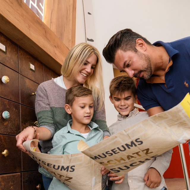 Das Bild zeigt eine Familie, die ein Rätsel im Kreismuseum Peine löst.