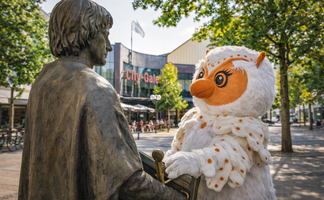 Maskottchen Uhlinchen begegnet der Statue von Graf Gunzelin auf dem Marktplatz in Peine vor der City-Galerie.