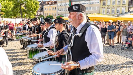 Mitglieder der Owl Town Pipe & Drum Band spielen beim Jubiläum von Peiner Heimstätte und Wohnbau Salzgitter auf dem Peiner Marktplatz.