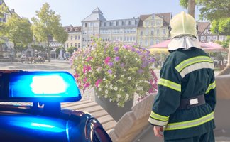 Das Bild zeigt das Blaulicht der Polizei und einen Feuerwehrmann auf dem Historischen Marktplatz in Peine. 