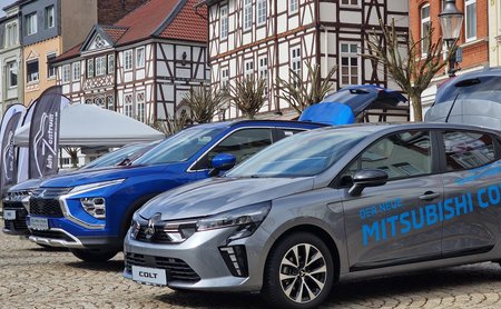 Ausgestellte Mitsubishi-Fahrzeuge auf dem Marktplatz in Peine, präsentiert vor historischer Fachwerkarchitektur bei einer öffentlichen Veranstaltung.