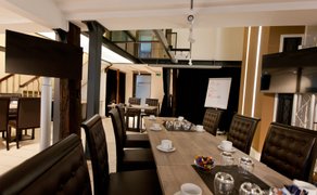 Moderner Tagungsraum im BusinessSchwan Peine mit Konferenztisch, gepolsterten Stühlen, Kaffeegedeck, Präsentationsmonitoren und Flipchart – ideal für Meetings, Seminare und Business-Events.