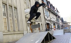 Skateboarder zeigt einen Sprungtrick über eine Rampe beim BraWo Mobility Spring in der Peiner Innenstadt vor historischer Kulisse.