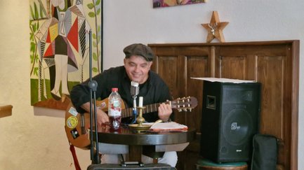 Das Bild zeigt einen Künstler, der in einer Kneipe in Peine Musik macht. 