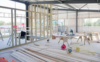 Umbau in einer Halle mit Holzständerwänden, Gerüst und Baumaterialien mit der KfW-Förderung Gewerbe zu Wohnen.