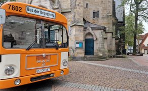 Historischer orangefarbener Bus „Bus der Begegnung“ vor der St.-Jacobi-Kirche in Peine als Teil der Kunst- und Kulturmeile in der Innenstadt