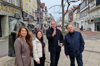 Vertreterinnen und Vertreter von Stadt Peine, Wirtschaftsförderung und Peine Marketing stehen in der Peiner Fußgängerzone. 