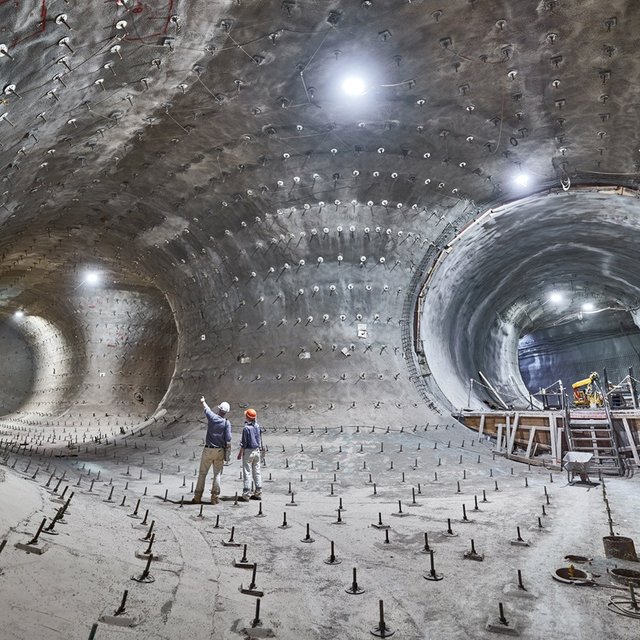 Das Bild zeigt Bergbauleute unter Tage in einer zum Teil bereits mit Beton verschalten Strecke.