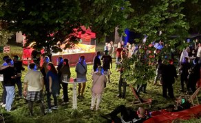 Gäste mit leuchtenden Kopfhörern stehen und tanzen bei der Silent Music Party Peine vor historischer Kulisse.