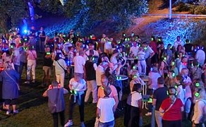 Große Menschenmenge bei einer Silent Disco in Peine: Besucherinnen und Besucher tanzen und feiern nachts im Freien mit leuchtenden Funkkopfhörern in verschiedenen Farben bei einer stimmungsvoll beleuchteten Musikveranstaltung.