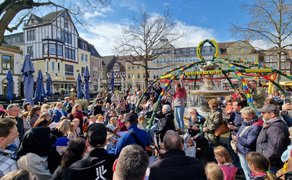 Viele Familien und Kinder versammeln sich auf dem Peiner Marktplatz rund um den festlich geschmückten Osterbrunnen.