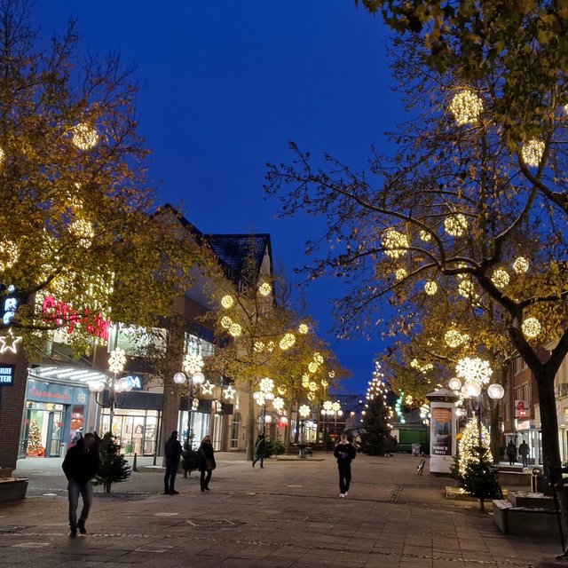 Das Bild zeigt die Südseite der Peiner Innenstadt, die zur Weihnachtszeit viele Leuchtbälle in den Bäumen trägt. 
