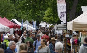 Großer Besucherandrang beim Highland Gathering: Dicht gedrängte Menschen schlendern zwischen Marktständen und Zelten unter grünen Bäumen – lebendige Festivalatmosphäre eines schottischen Kultur- und Genussmarktes.