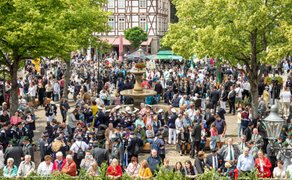 Großes Besucheraufkommen auf dem Peiner Marktplatz beim Peiner Freischießen, mit Schützen in Uniform, Brunnen im Zentrum und historischer Fachwerkkulisse.