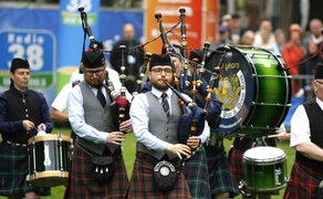 Gruppe von Musikern in Kilts spielt Dudelsäcke und Schlagzeug beim Highland Gathering im Peiner Stadtpark