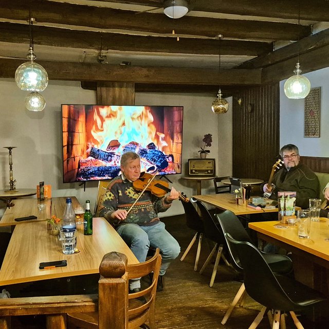 Das Bild zeigt eine Gruppe von Musikern, die zusammen Musik machen. 