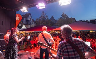 Das Bild zeigt eine Band, die beim Peiner Weinfest auf der Bühne steht.