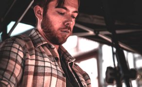 Musiker Buddy Schmidt spielt bei einem Live-Auftritt Gitarre und singt in ein Mikrofon