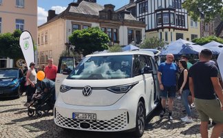 Elektrofahrzeug von Volkswagen beim BraWo Mobility Spring in der Peiner Innenstadt, umgeben von Besucherinnen und Besuchern auf dem Marktplatz während des Mobilitäts- und Familienevents.