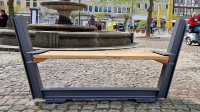 Moderne Sitzbank auf dem Peiner Marktplatz vor dem Brunnen als Teil der Innenstadtmöblierung mit Aufenthaltsqualität im urbanem Stadtraum