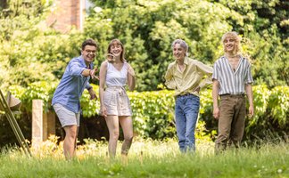 Das Bild zeigt eine Gruppe junger Menschen, die im Burgpark Peine ein Spiel spielen. 