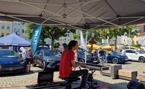 Live-Musiker an Keyboard und Mikrofon auf der Open Stage in Peine, im Hintergrund Autoshow, Besucherinnen und Besucher sowie der Marktplatz mit Sonnenschirmen und Fachwerkhäusern.