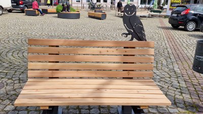 Das Bild zeigt eine Bank mit einer stiliserten Eule auf dem Historischen Marktplatz in Peine, was als Kunst im öffentlichen Raum gilt. 