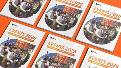 Mehrere Broschüren mit dem Titel „Events 2026“ von Peine liegen auf orangefarbenem Hintergrund. Auf dem Cover ist eine Dudelsack-Band bei einer Veranstaltung zu sehen.