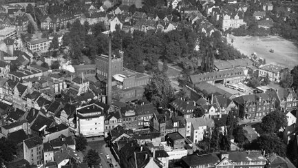 Die historische Luftaufnahme zeigt die Härke Brauerei Peine als prägenden Bestandteil der Stadtstruktur und Industriegeschichte. Deutlich erkennbar sind die Brauereigebäude mit Schornstein, die den regionalen Biergenuss und die wirtschaftliche Bedeutung von Härke für Peine dokumentieren.