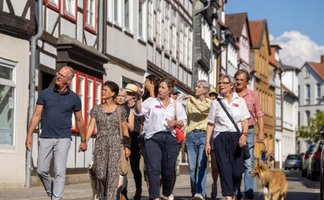 Stadtführung in Peine mit Gruppe von Teilnehmern und Stadtführerin durch historische Fachwerkstraße in der Peiner Innenstadt.