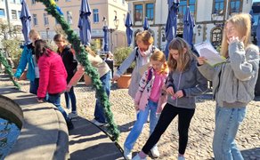 Schüler stehen am Rand des Brunnens auf dem Historischen Marktplatz in Peine.