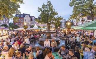 Das Bild zeigt viele Menschen auf dem Historischen Marktplatz in Peine, die es sich beim Weinfest gutgehen lassen. 