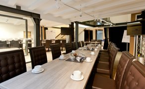 Moderner Tagungsraum im BusinessSchwan Peine mit langem Konferenztisch, gedeckten Kaffeetassen, bequemen Lederstühlen und professioneller Präsentationstechnik für Meetings und Seminare.