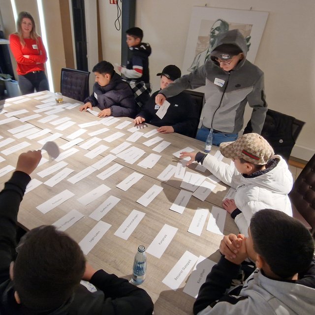 Teilnehmende Kinder und Jugendliche arbeiten gemeinsam an einem Workshop zur Stadtentwicklung in Peine, ordnen Begriffe und diskutieren Ideen für die Zukunft der Stadt.