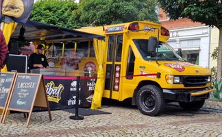 Gelber Streetfood-Truck beim Food Truck Festival in Peine mit frisch zubereiteten Burgern – darunter Wagyu Beef und Krokodil-Burger – direkt auf dem Marktplatz serviert.