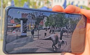 Das Bild zeigt die virtuelle Dino-City in einem Smartphone.