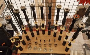 Auswahl verschiedener Dudelsack-Blasrohre und Zubehörteile aus Holz und Metall, ordentlich auf einem Verkaufsstand beim Highland Gathering präsentiert.