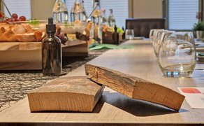 Auf einem gedeckten Tisch liegen im Vordergrund zwei Holzstückchen aus einem Whiskyfass.