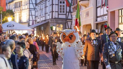 Uhlinchen läuft beim Fackelumzug durch die Peiner Innenstadt, begleitet von Schützen und Zuschauern vor historischer Fachwerkkulisse.