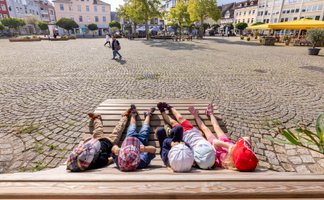 Das Bild zeigt eine Gruppe Kinder, die auf einer Liege liegen und sich den Historischen Marktplatz in Peine anschauen. 
