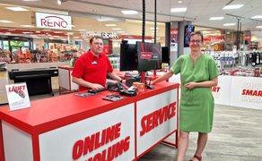 Zwei Mitarbeitende stehen an einer Service- und Abholtheke in einem Elektronikfachmarkt