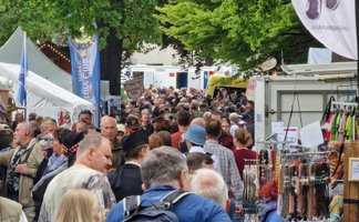 Viele Besucher schlendern dicht gedrängt durch einen belebten Markt mit Ständen und Zelten bei einer Veranstaltung in Peine.