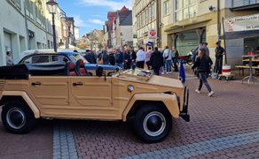 Oldtimer-Kübelwagen beim BraWo Mobility Spring in der Innenstadt Peine, umgeben von Besuchern und Straßenfest-Atmosphäre.
