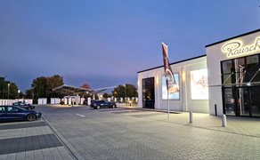 Das Bild zeigt ein Gebäude mit der Aufschrift "Rausch" in der Abendstimmung. 