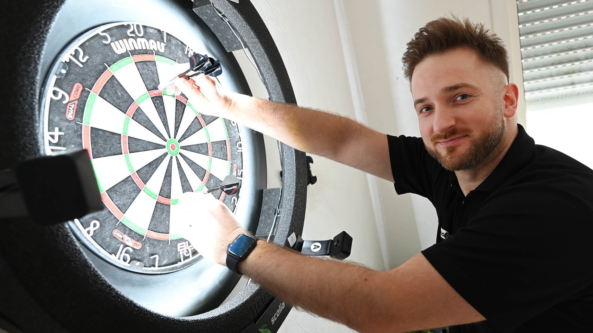 Porträt des Dartspielers Arno Merk aus Peine-Vöhrum am Dartboard, stellvertretend für den Darts-WM-Bezug und einem Interview mit dem Darts-Profi
