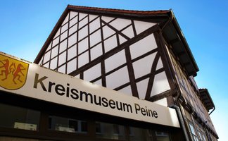 Das Bild zeigt den Eingang des Kreismuseum Peine, mit dessen Schriftzug über der Eingangstür.