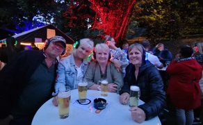 Das Bild zeigt eine Gruppe Menschen die bei der Silent Music Party im Burgpark Peine feiern. 