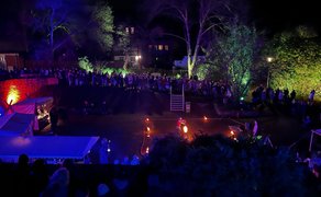 Besucher erleben den Winterzauber in Peine mit Feuer- und Lichtshow im stimmungsvoll beleuchteten Burgpark bei Nacht.