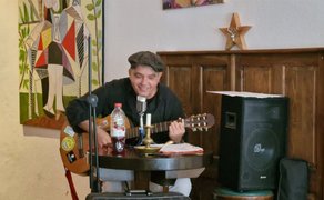 Musiker mit Gitarre bei einem Live-Auftritt im Rahmen der Kunst- und Kulturmeile in Peine, intime Atmosphäre mit Musik, Mikrofon und Publikum im Innenraum