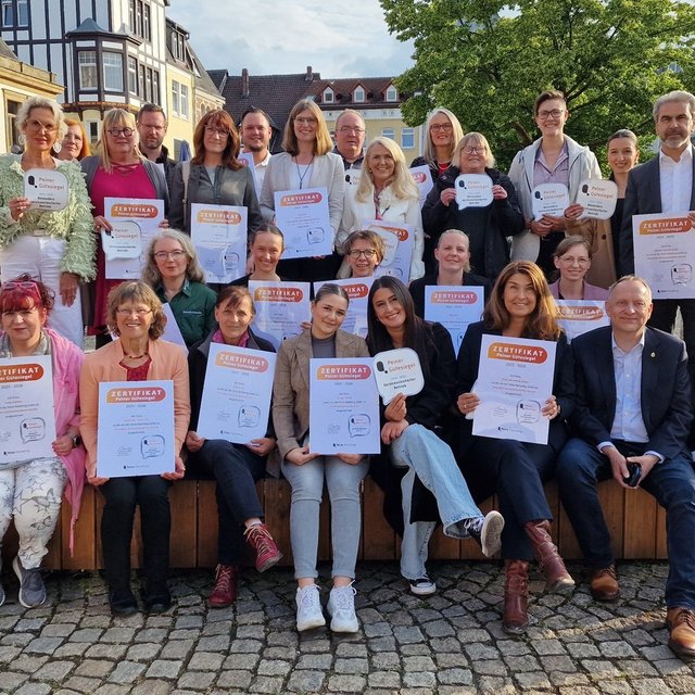 Gruppenfoto zur Verleihung des Peiner Gütesiegels: Ausgezeichnete Betriebe präsentieren ihre Zertifikate auf dem Historischen Marktplatz in Peine.